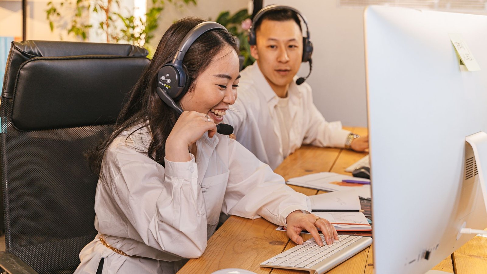 Dois atendentes de suporte ao cliente trabalhando com headset