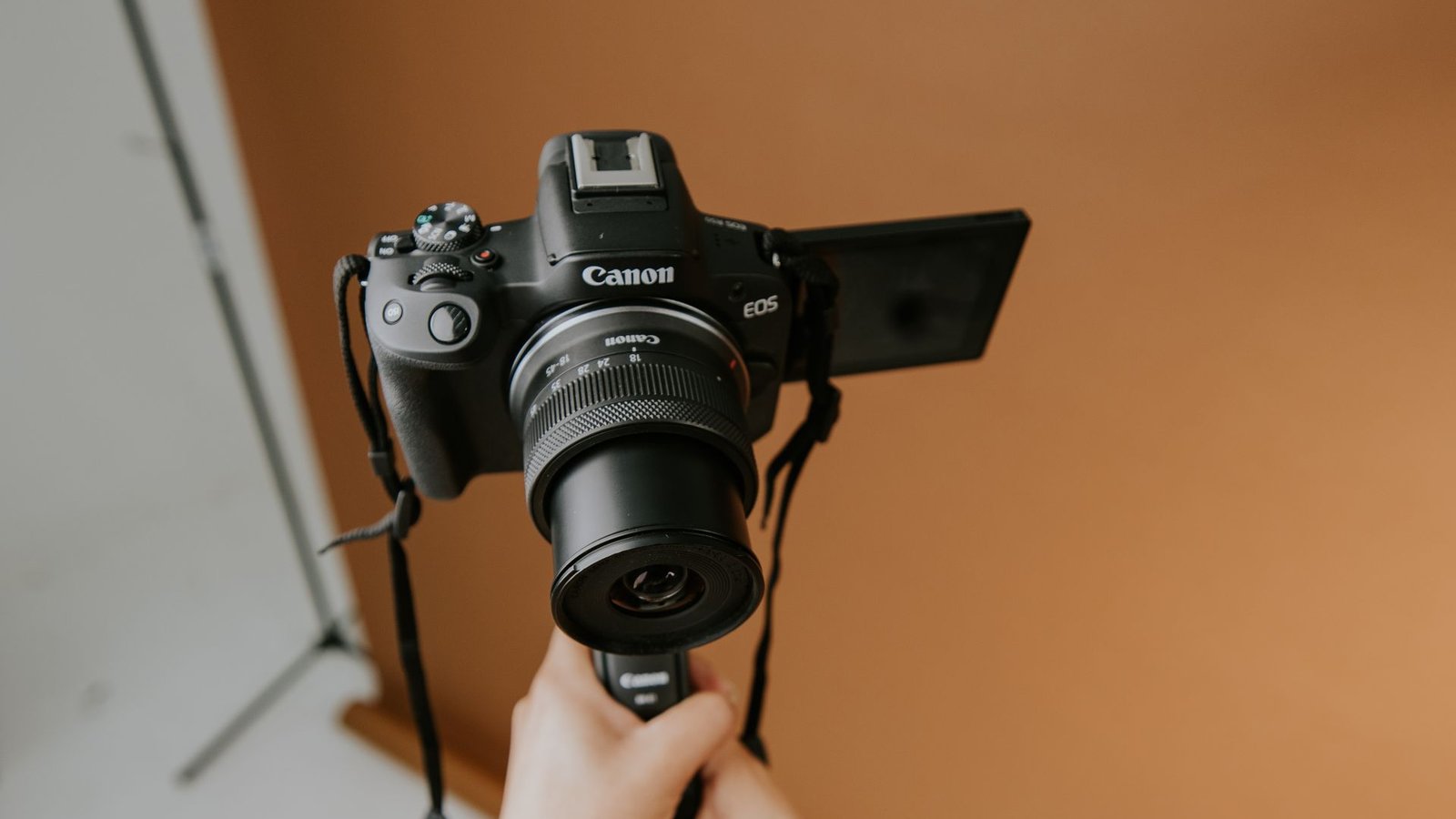 Fotógrafo segurando câmera profissional em estúdio