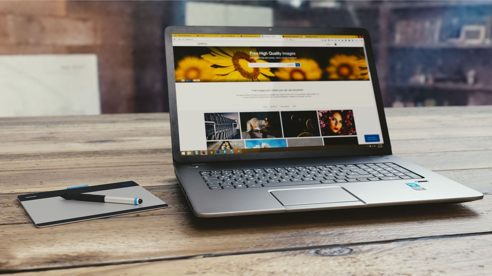 Laptop cinza aberto mostrando página web sobre mesa de madeira