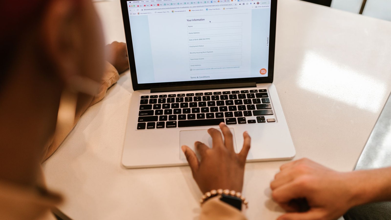 Pessoas preenchendo formulário online em laptop representando captura de lead